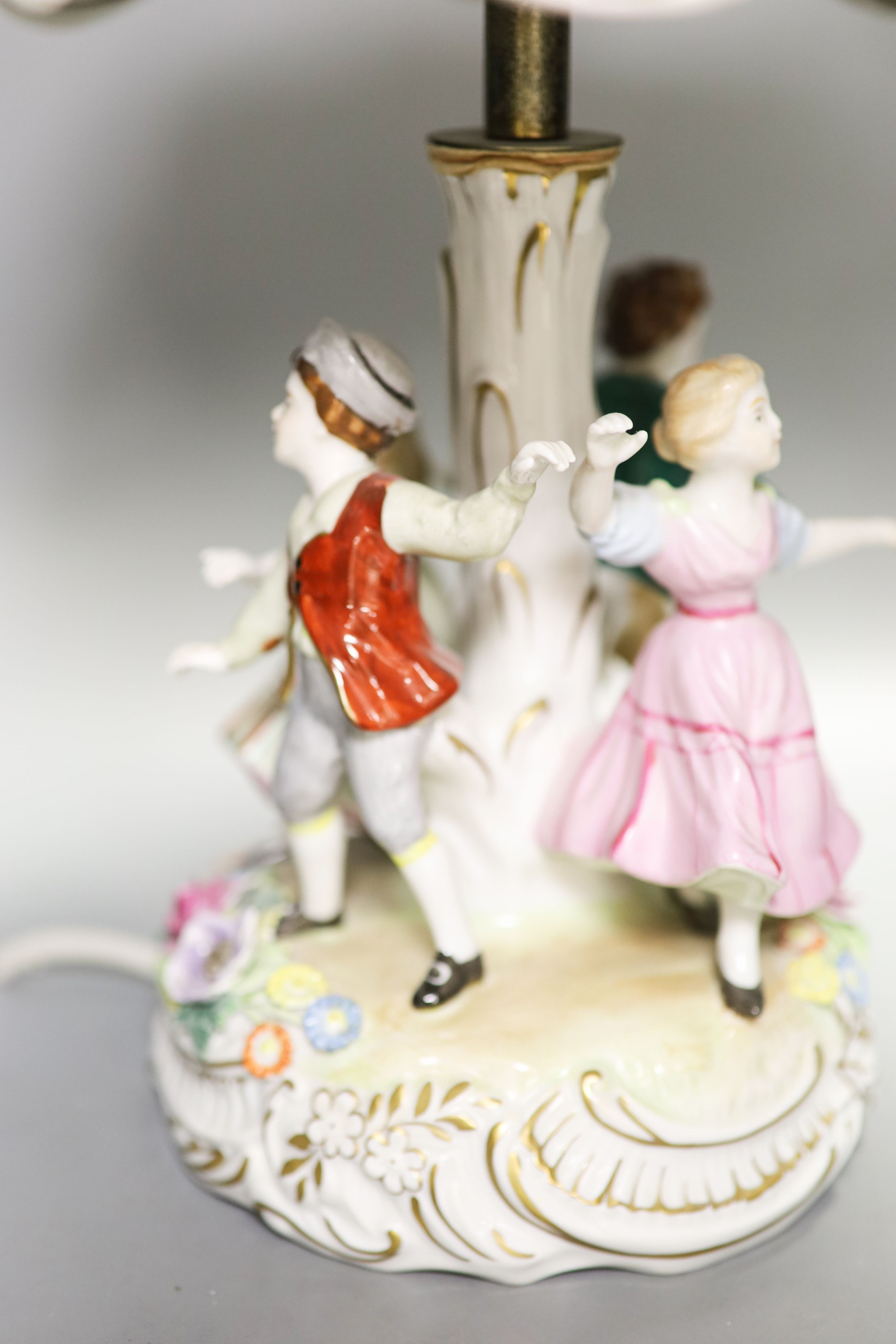 Two pairs of German porcelain table lamps, the stems modelled with figures dancing 56cm